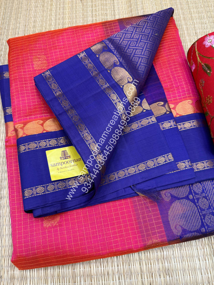 Peachish Pink with Blue , Rich Zari checks in the body , Mayil and Chakram rich butta in the body , Rettapet border and Grand Pallu Korvai Silk Cotton Saree