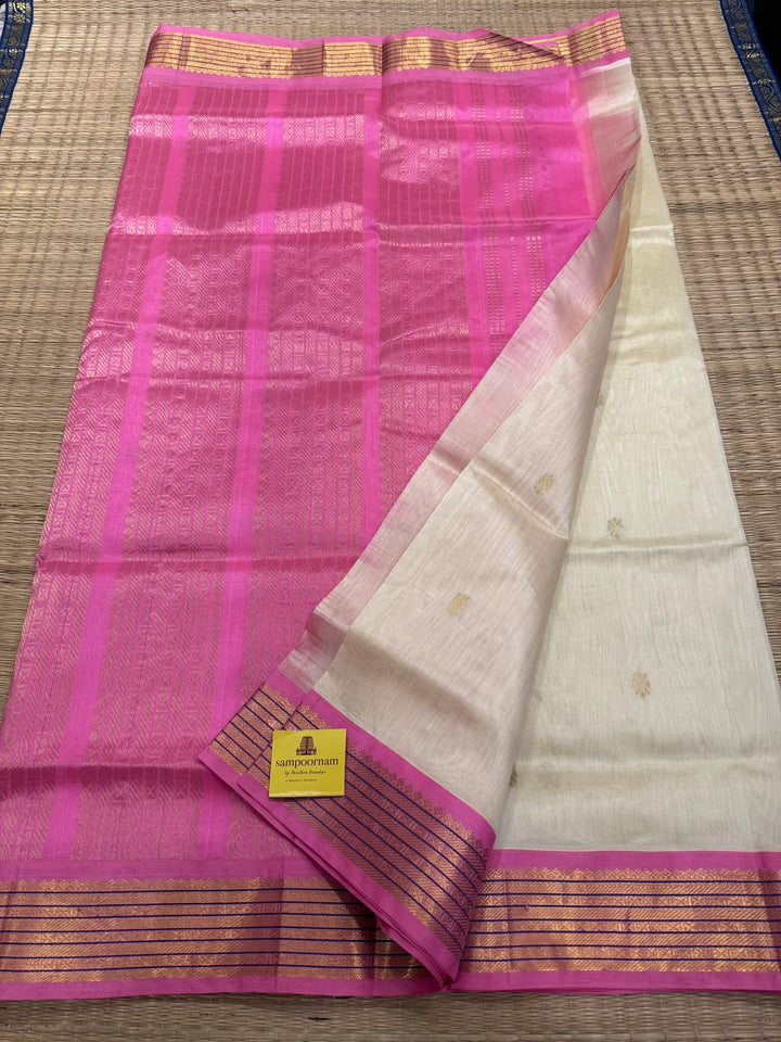 OffWhite with Baby Pink , rich zari butta in the body , traditional borders and rich Pallu Korvai Silk Cotton Saree