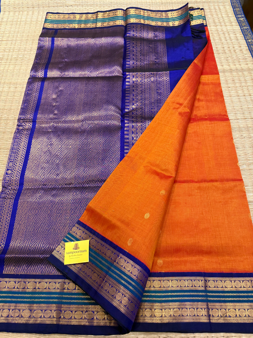 Rust Orange with Dark Blue , rich zari butta in the body , traditional borders and rich Pallu Korvai Silk Cotton Saree