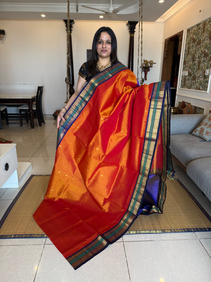 Rust Orange with Dark Blue , rich zari butta in the body , traditional borders and rich Pallu Korvai Silk Cotton Saree