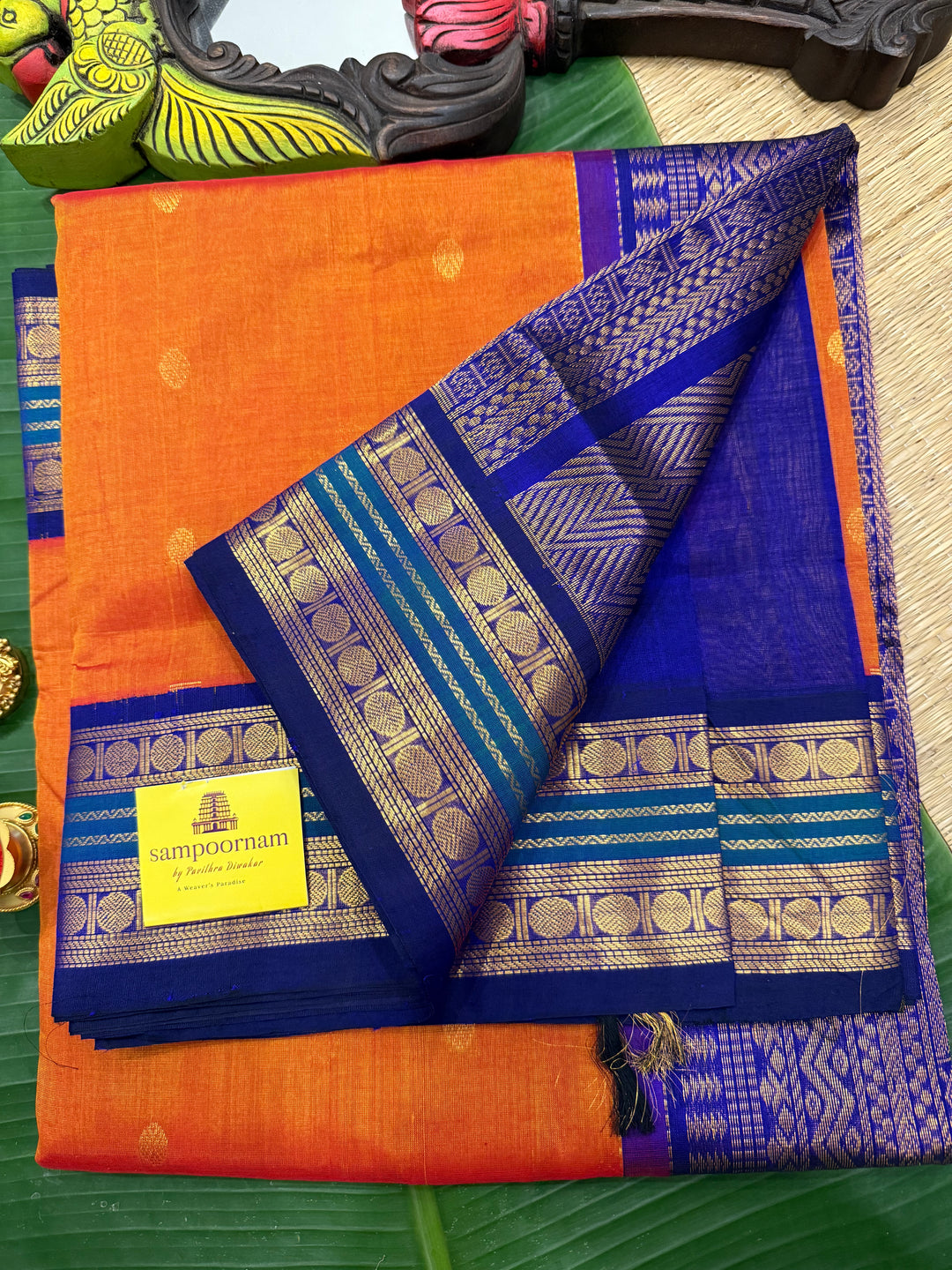 Rust Orange with Dark Blue , rich zari butta in the body , traditional borders and rich Pallu Korvai Silk Cotton Saree