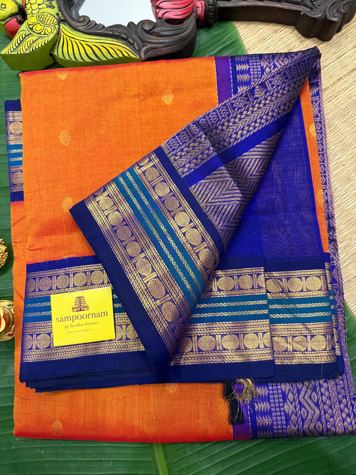 Rust Orange with Dark Blue , rich zari butta in the body , traditional borders and rich Pallu Korvai Silk Cotton Saree