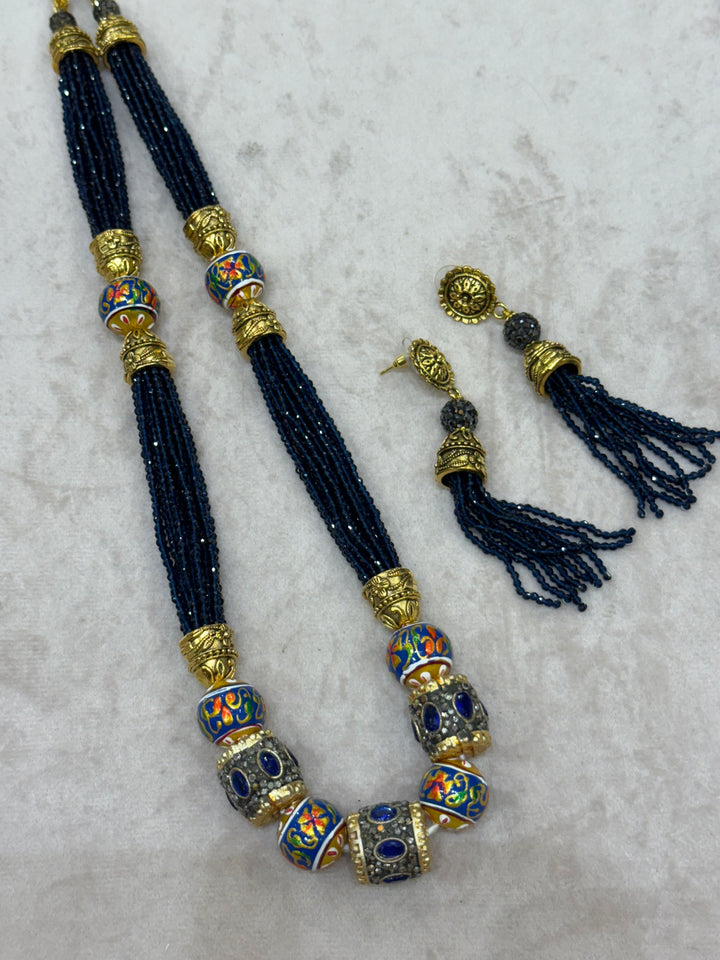 Dark Blue multi crystal bead stranded neckpiece adorned with antique gold elements and intricate meenakari balls, paired with tassel shaped eardrops