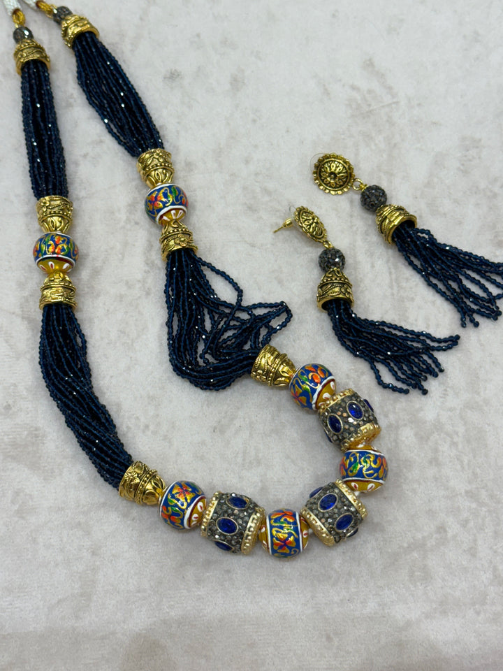 Dark Blue multi crystal bead stranded neckpiece adorned with antique gold elements and intricate meenakari balls, paired with tassel shaped eardrops