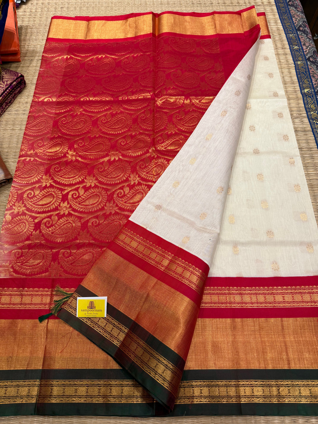 Offwhite with Red one side triple rich border in Red , Green and Gold , grand Pallu ,rich Zari butta in the body  Korvai Silk Cotton Saree