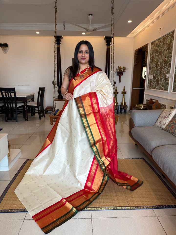 Offwhite with Red one side triple rich border in Red , Green and Gold , grand Pallu ,rich Zari butta in the body  Korvai Silk Cotton Saree