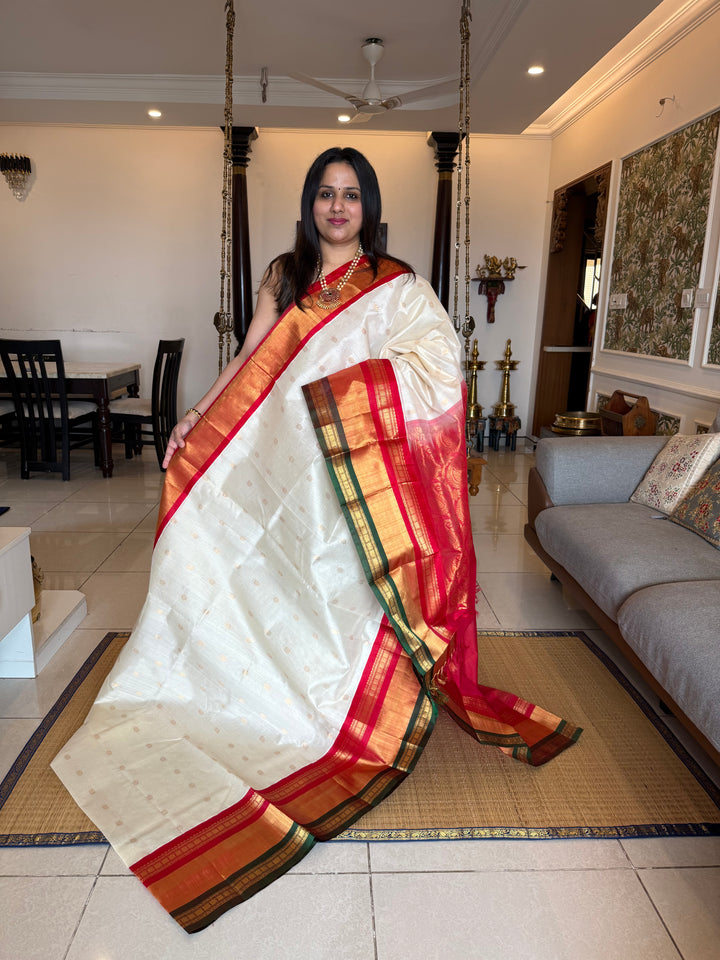 Offwhite with Red one side triple rich border in Red , Green and Gold , grand Pallu ,rich Zari butta in the body  Korvai Silk Cotton Saree