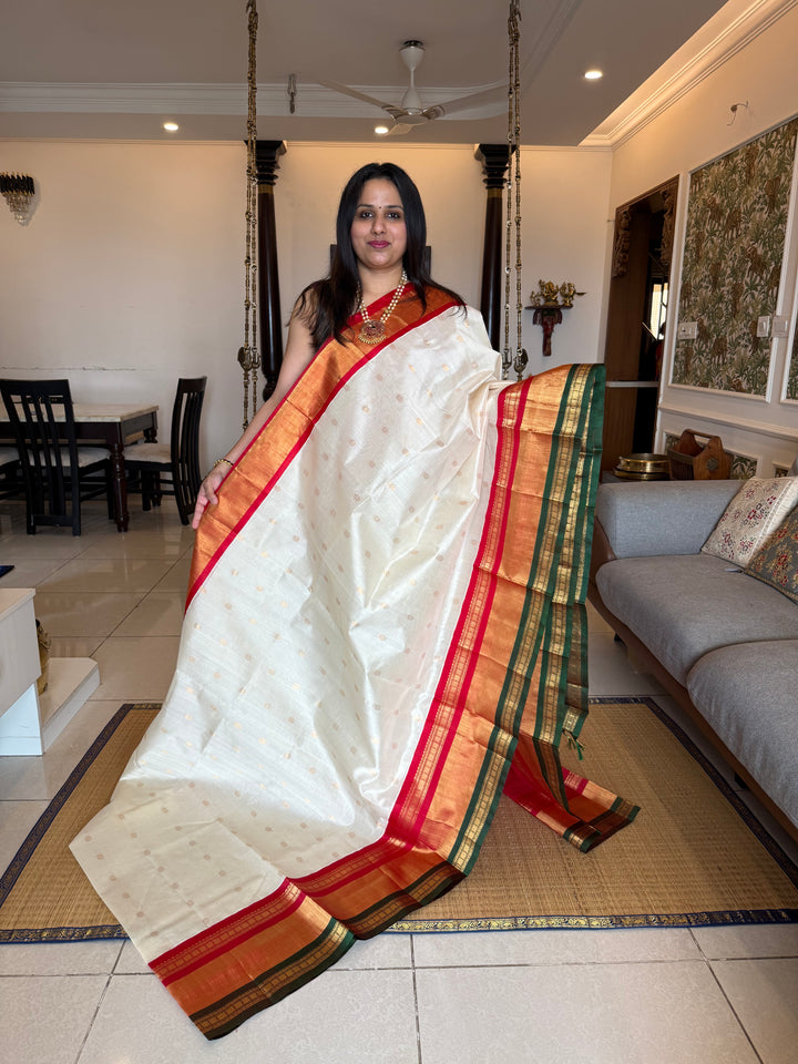 Offwhite with Red one side triple rich border in Red , Green and Gold , grand Pallu ,rich Zari butta in the body  Korvai Silk Cotton Saree