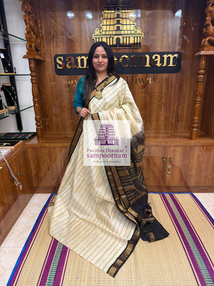 Offwhite with Black , traditional borders with Veldhari lines in the body and grand Pallu Korvai Silk Cotton Saree