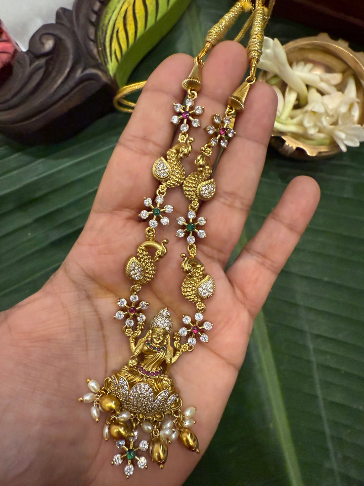 Divine Elegance , A traditional Necklace with a Mahalakshmi Pendant in red green and white stones with peacock detailing