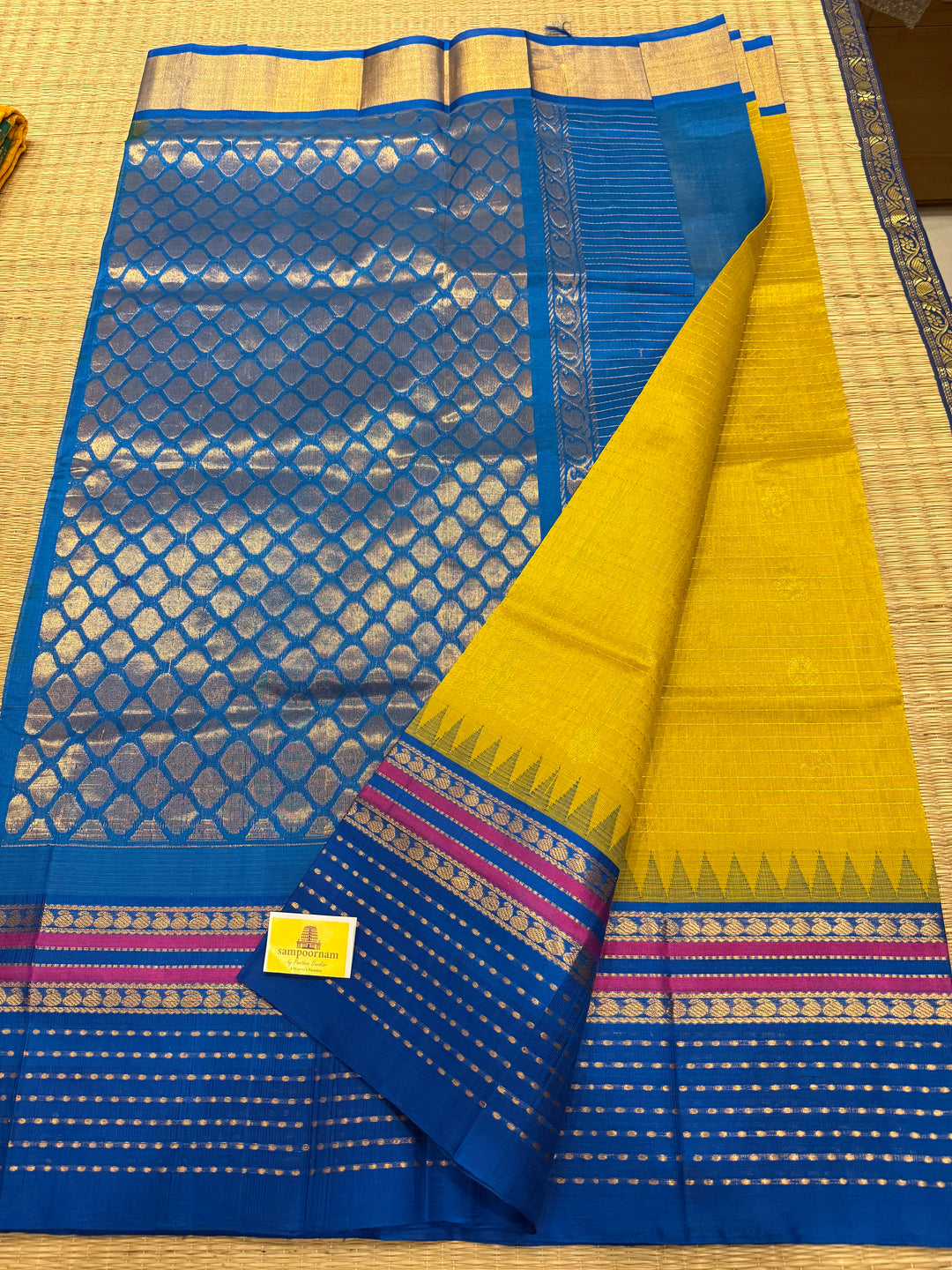 Yellow with Copper Sulphate Blue one side big border with Lakshadeepam butta , Zari butta in the body with Zari checks and grand Pallu Korvai Silk Cotton Saree