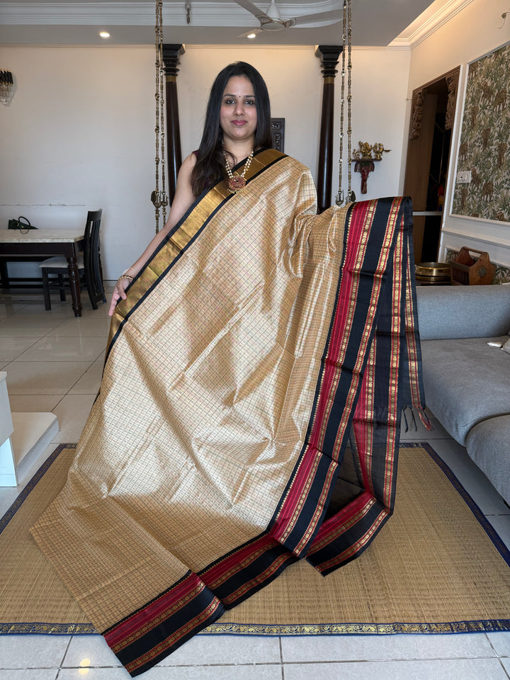 Biscuit and Black , Lakshadeepam Zari butta in the body and rettapet traditional borders and rich Pallu Korvai Silk Cotton Saree