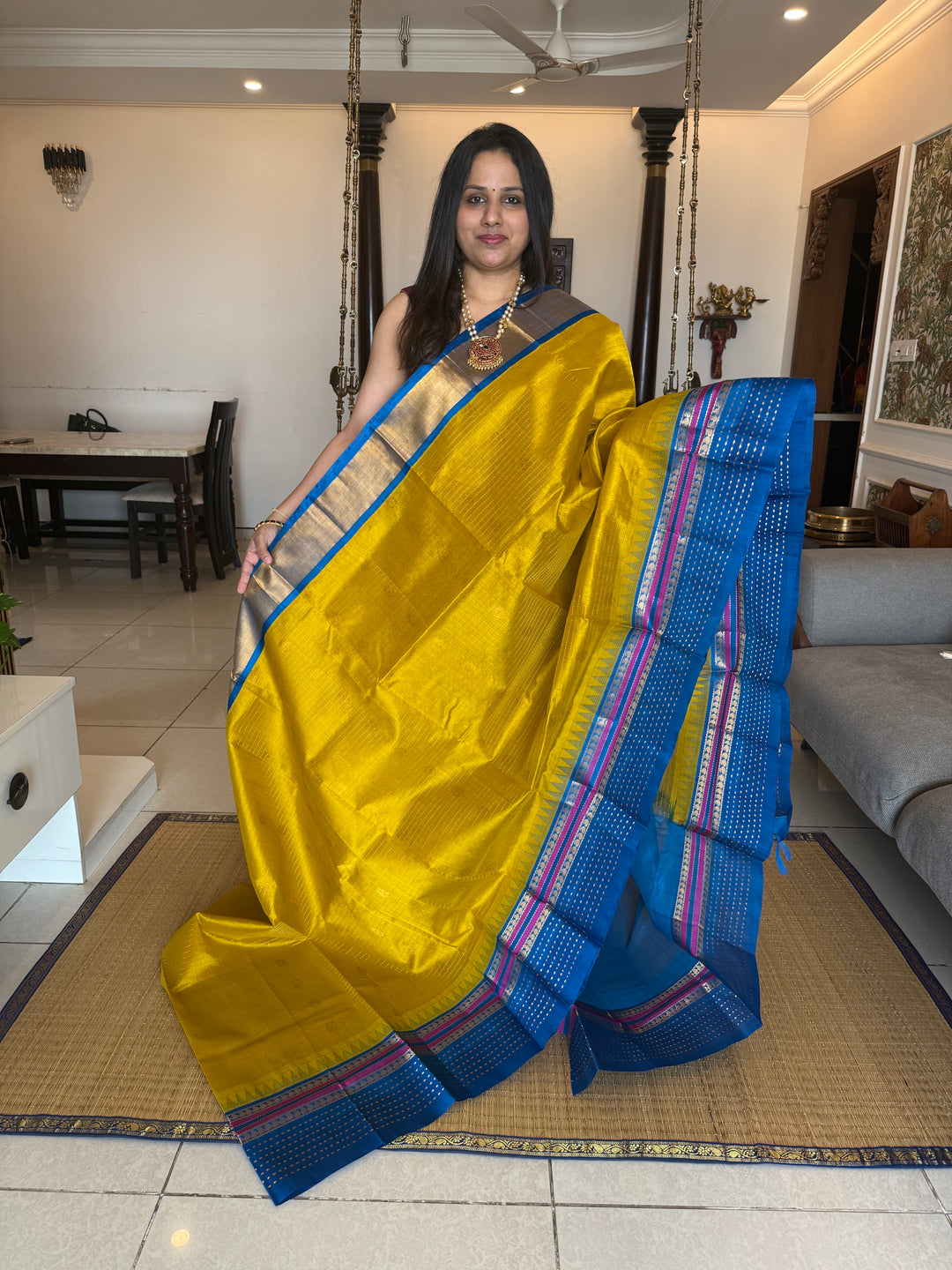 Yellow with Copper Sulphate Blue one side big border with Lakshadeepam butta , Zari butta in the body with Zari checks and grand Pallu Korvai Silk Cotton Saree