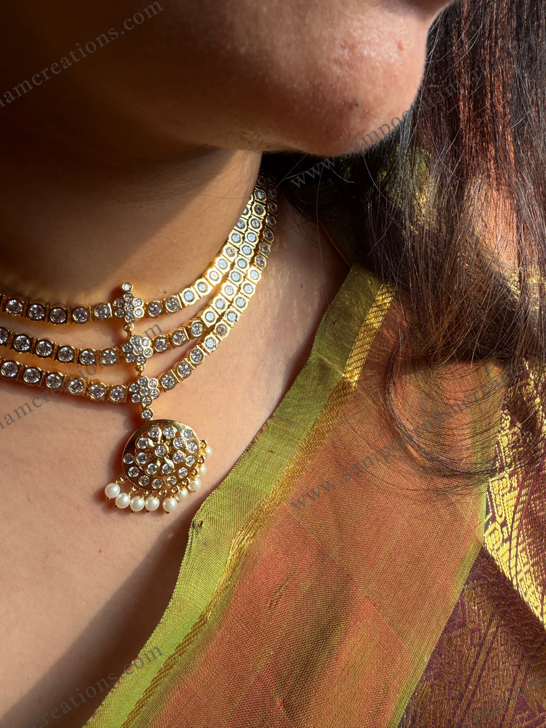 Classic three line white stone adigai with pendant finished with elegant pearl hangings. Comes with matching ear drops  a timeless, traditional neckpiece perfect for sarees.