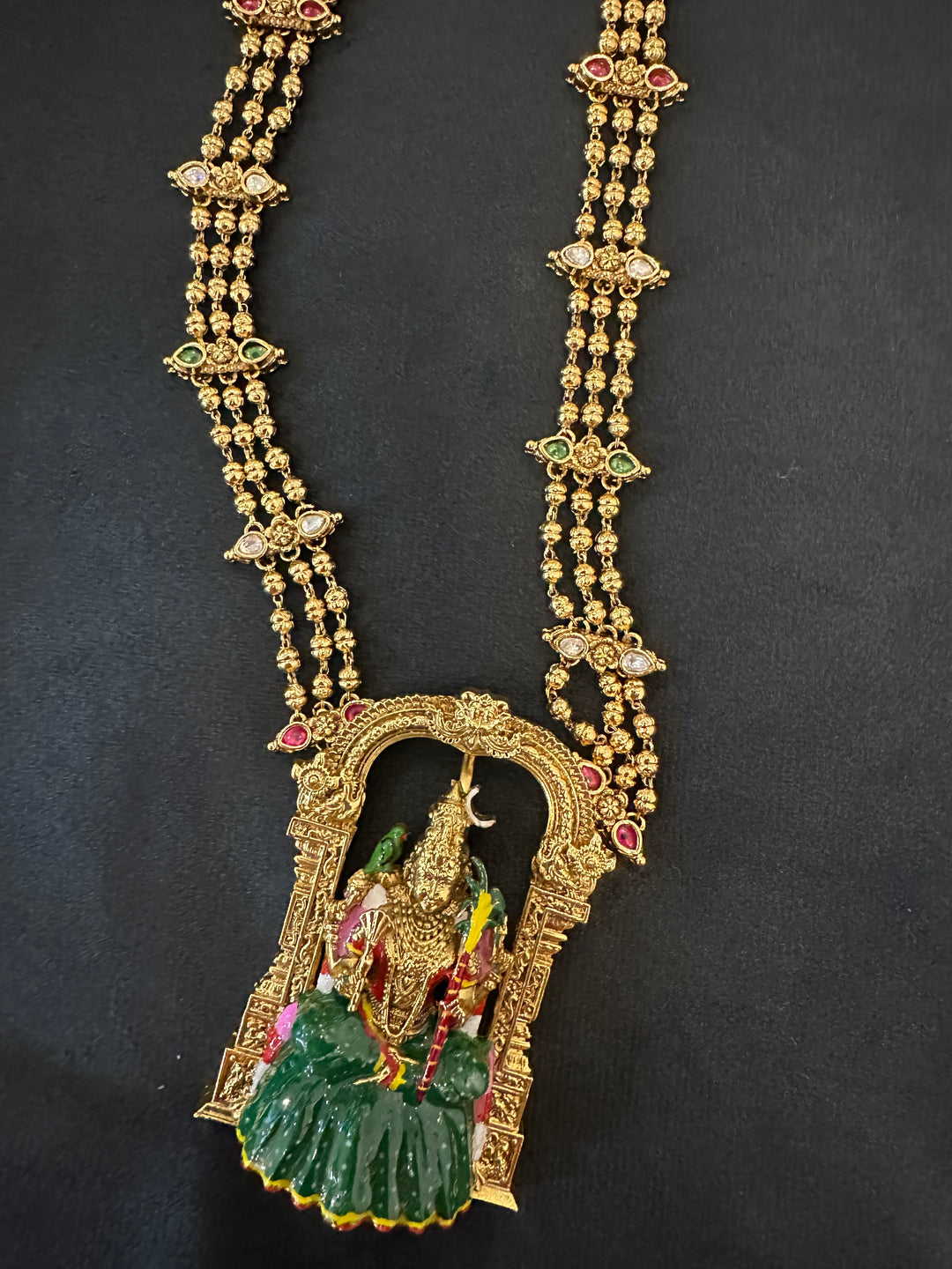 A classic three layer beaded neck piece with gold balls , red , green and white kemp stones , with Goddess Kamakshi Amman 3D Pendant .