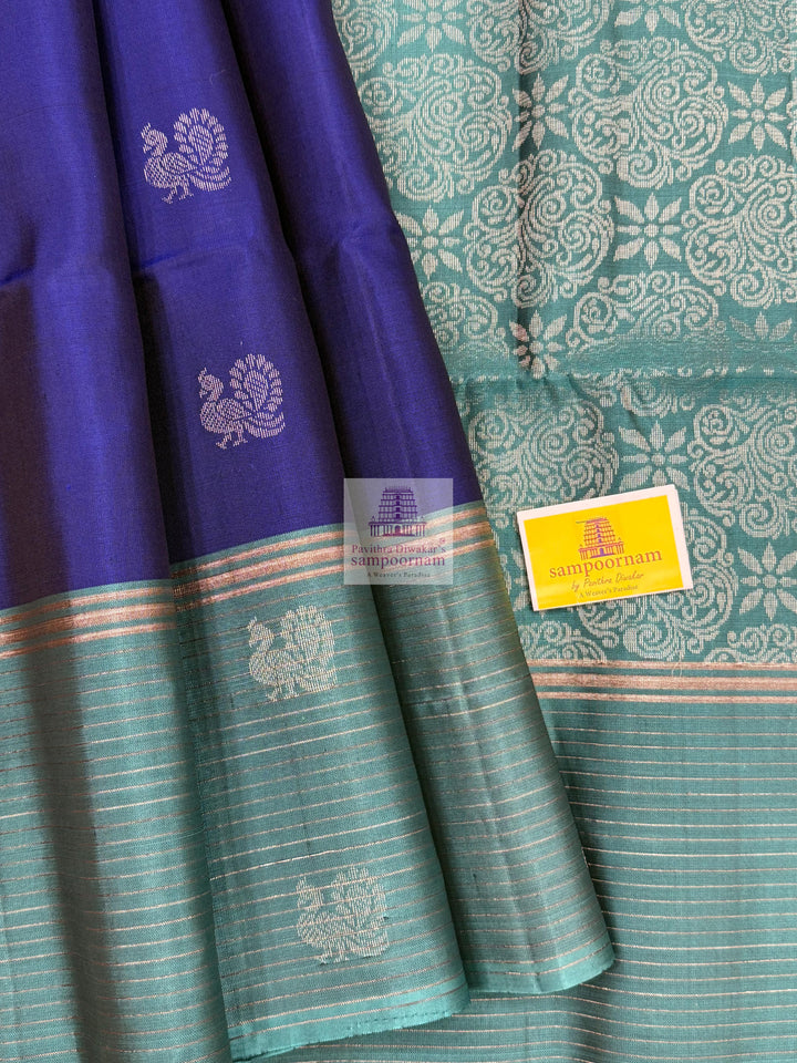 Dark Blue with Teel Blue ,  Zari lines in the border , Annam and Chakram butta in the body and rich Pallu Pure Soft Silk Saree