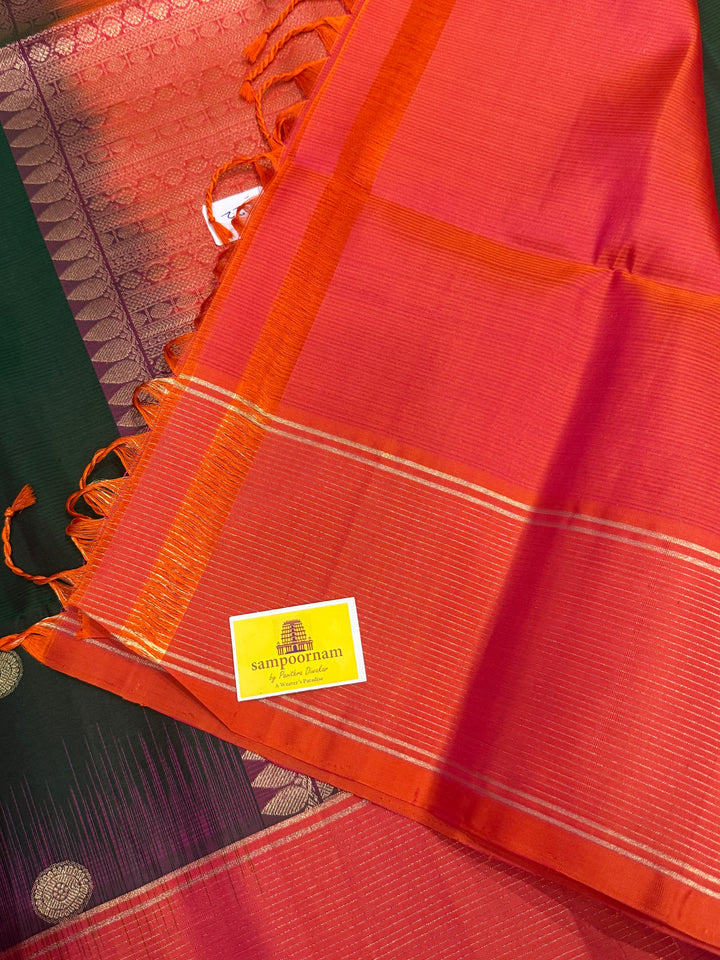 Dark Green with Pinkish Orange , rich zari annam and rudraksh butta in the body , vairaoosi borders and rich Pallu , pure soft silk saree