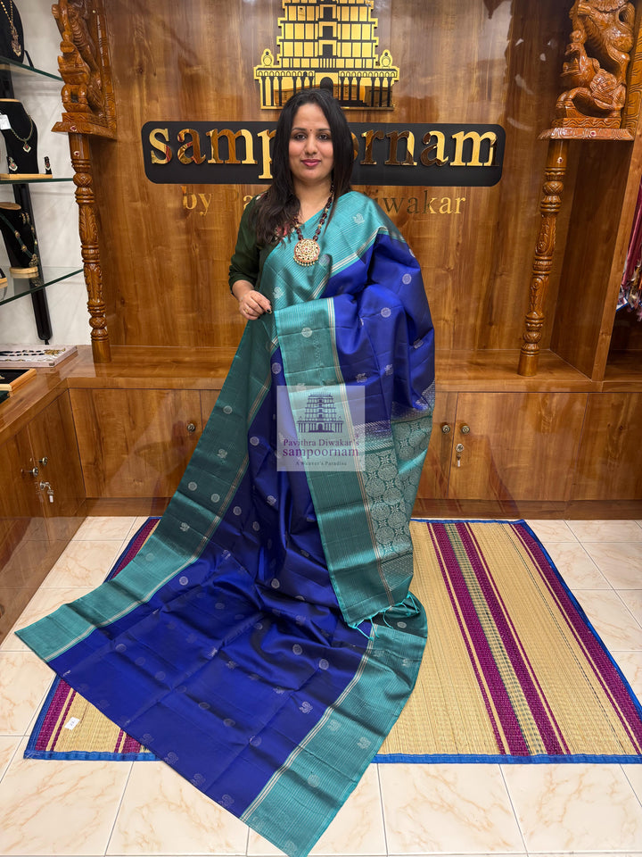 Dark Blue with Teel Blue ,  Zari lines in the border , Annam and Chakram butta in the body and rich Pallu Pure Soft Silk Saree