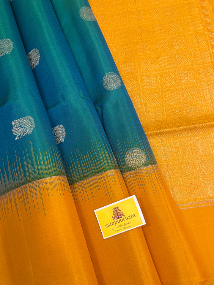 Greenish Blue with Manjal , rich zari rudraksh butta in the body , plain borders and rich Pallu , pure soft silk saree