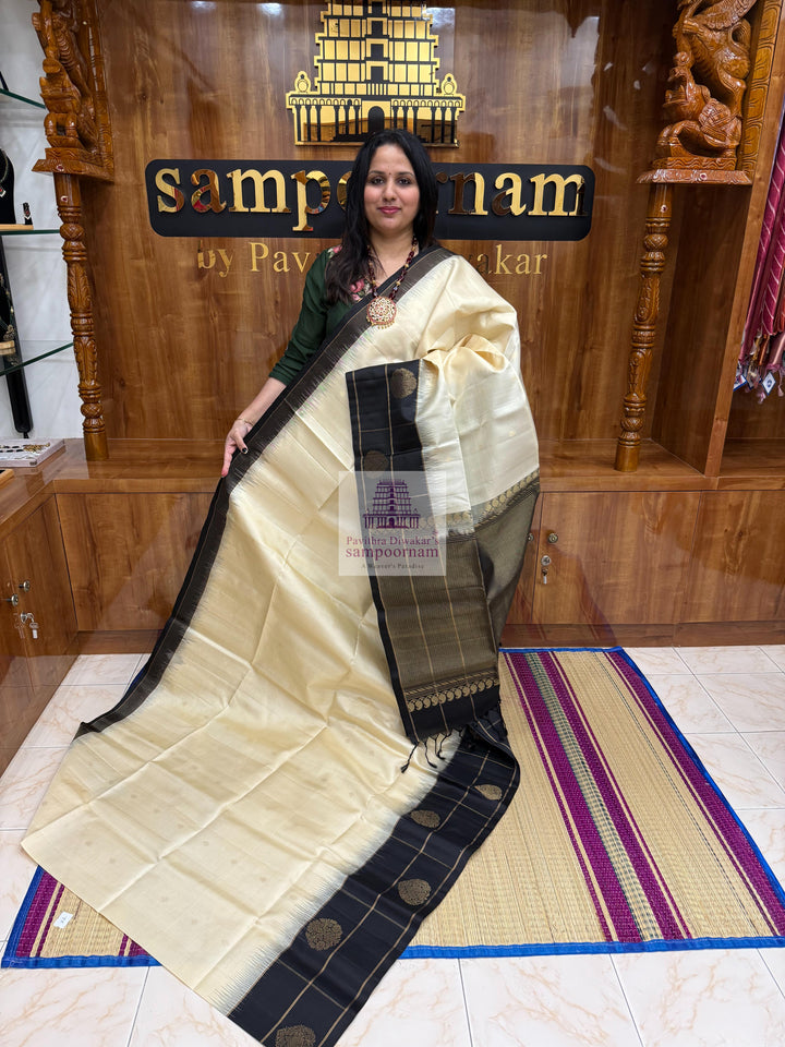 Offwhite with Black , one side big border , Vairaoosi lines and rich Zari butta in the body and grand  Pallu Pure Soft Silk Saree