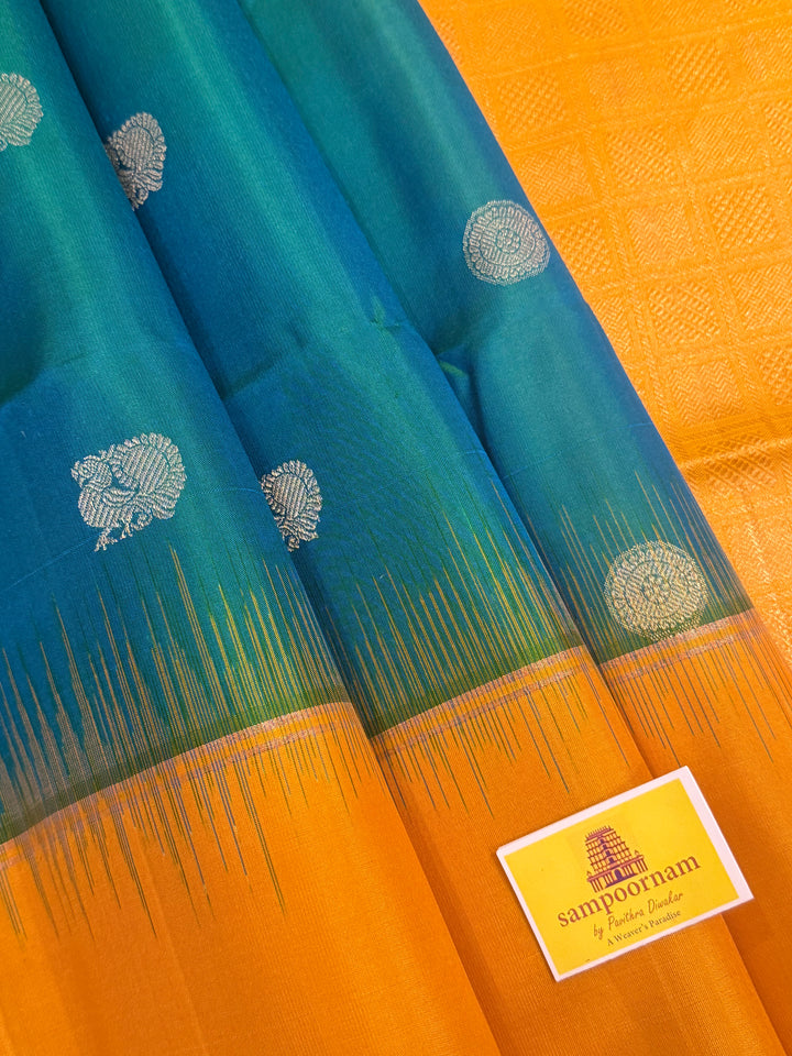 Greenish Blue with Manjal , rich zari rudraksh butta in the body , plain borders and rich Pallu , pure soft silk saree
