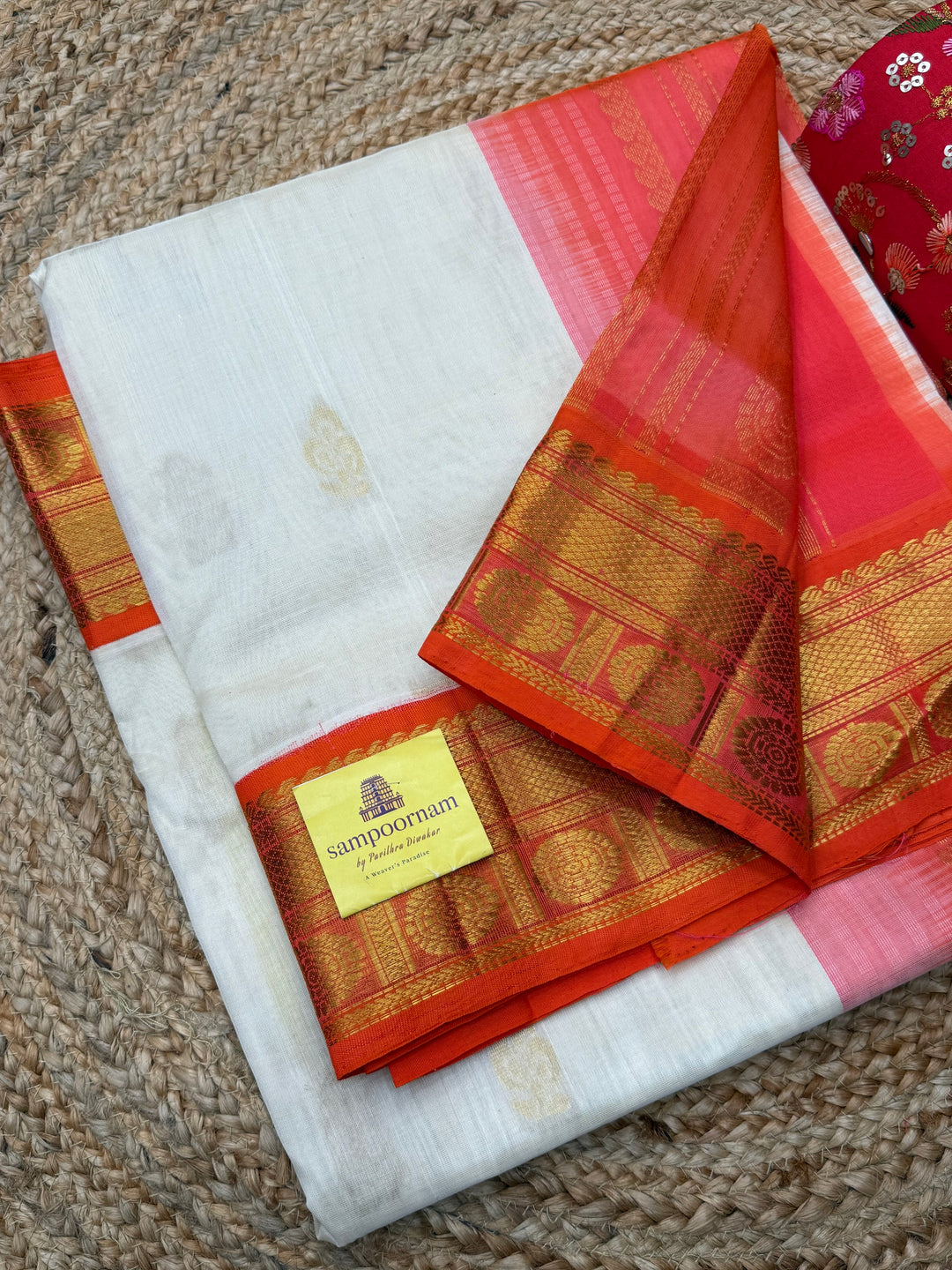 Offwhite with Orange , rich Floral Zari butta in the body and Traditional Borders , rich Pallu Korvai Silk Cotton Saree