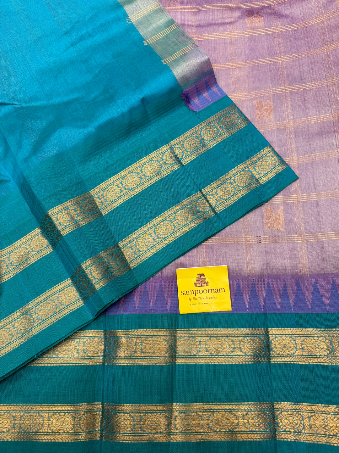 Lilac with Turquoise Blue , Zari Checks with Mayil and Chakram rich Butta  in the body and rettapet border , rich Pallu Korvai Silk Cotton Saree