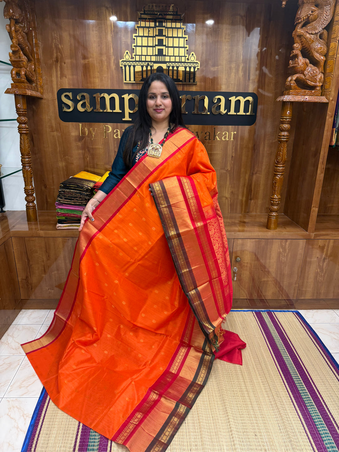 Rust Orange with Red  , rich Floral Zari butta in the body  and One side Triple  Borders , rich Pallu Korvai Silk Cotton Saree