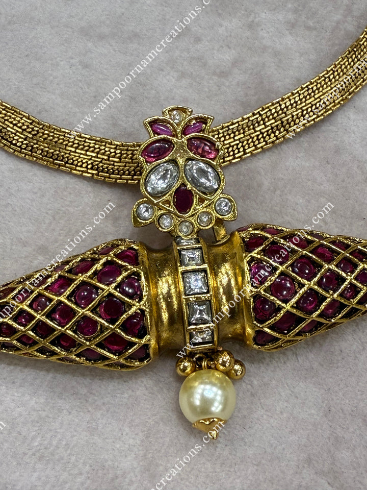 This heritage inspired necklace features a striking two cone shaped pendant adorned with rich red stones and shimmering white stones — a timeless design rooted in South Indian elegance