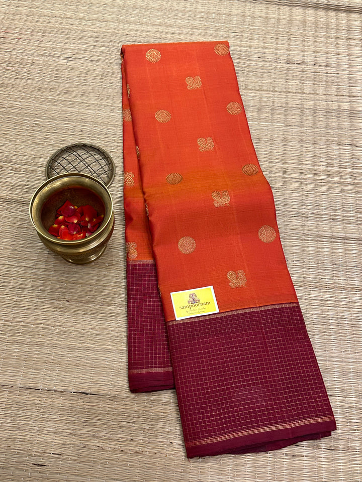 A Traditional Dark orange with Araku , Zari Checks Border , Mayil Chakram Zari Butta in Body and Traditional Rich Pallu Pure Kanjivaram Silk Saree