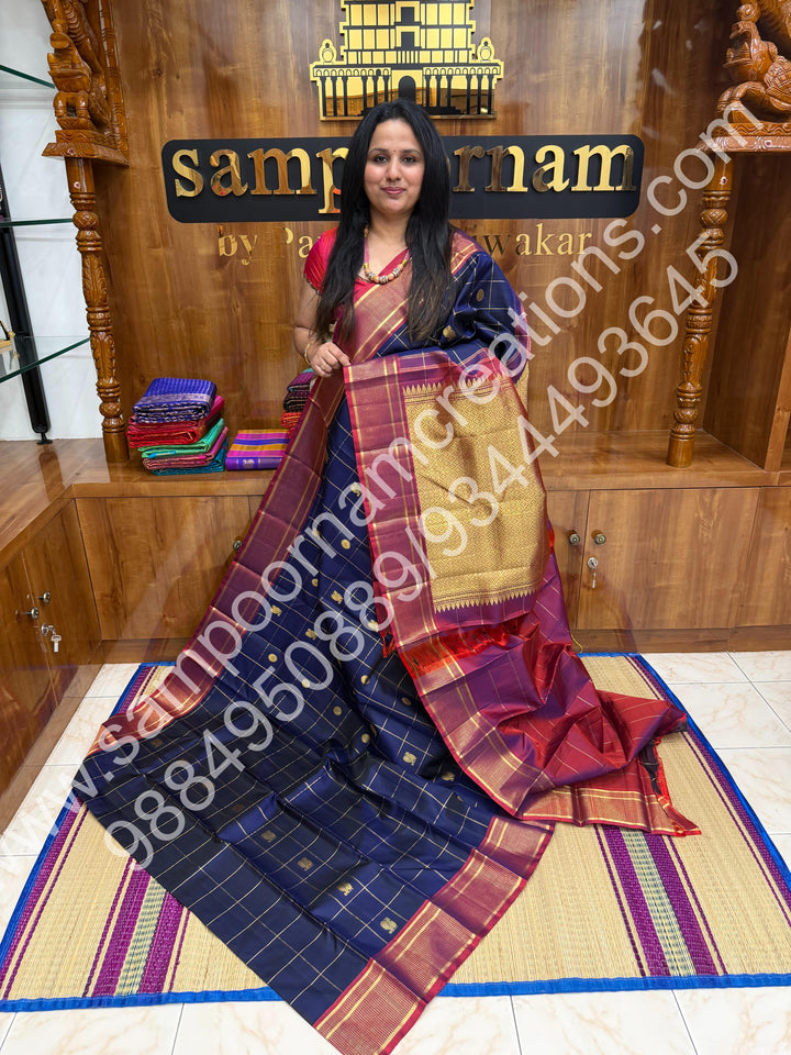 Dark Blue with Mauve , Rich Mayil and Chakram  butta in the body with Zari checks , Traditional borders and Rich Pallu , Pure Kanjivaram Silk Saree