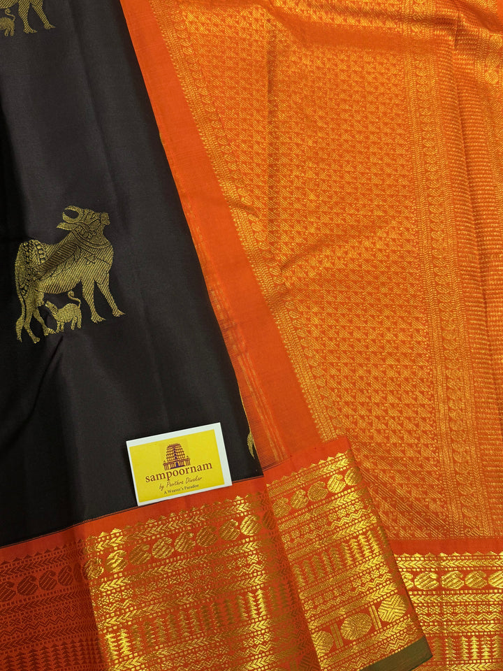 A classic Dark Podi Brown Colour with Fanta Orange Gomatha Cow and Calf Zari Motifs in the Body and Tradition Borders and Rich Pallu Pure Kanjivaram Silk Saree
