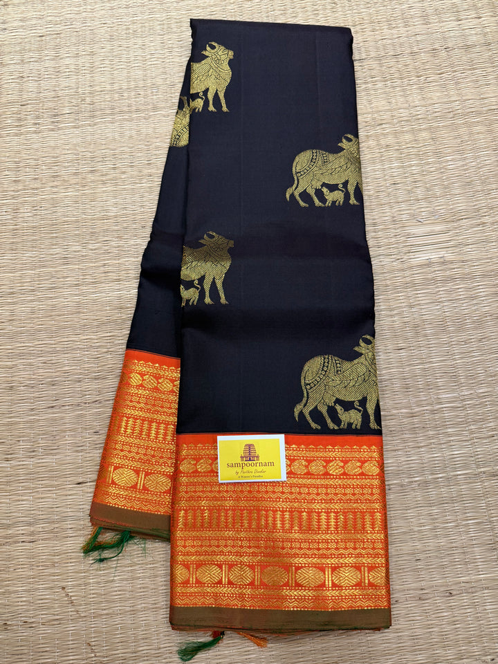A classic Dark Podi Brown Colour with Fanta Orange Gomatha Cow and Calf Zari Motifs in the Body and Tradition Borders and Rich Pallu Pure Kanjivaram Silk Saree