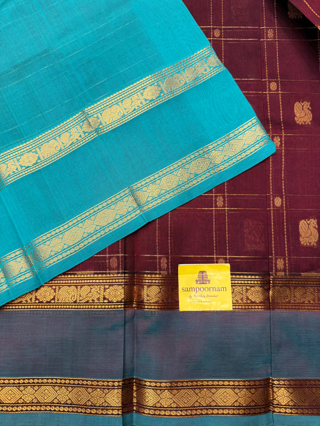 Arakku with Turquoise  , Zari Checks with Chakram and Mayil butta in the body , Traditional borders and  rich Pallu Silk Cotton Saree