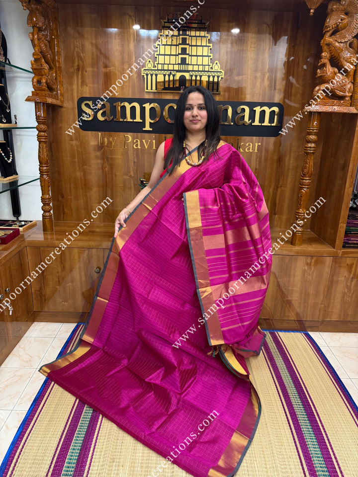 Dark Magenta , Green Selvedge , Rich Zari Checks in the body , traditional borders and rich Pallu Silk Cotton Saree