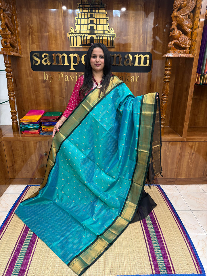 Teel Blue with Black , Zari Checks with Chakram and Mayil butta in the body , Traditional borders and  rich Pallu Silk Cotton Saree