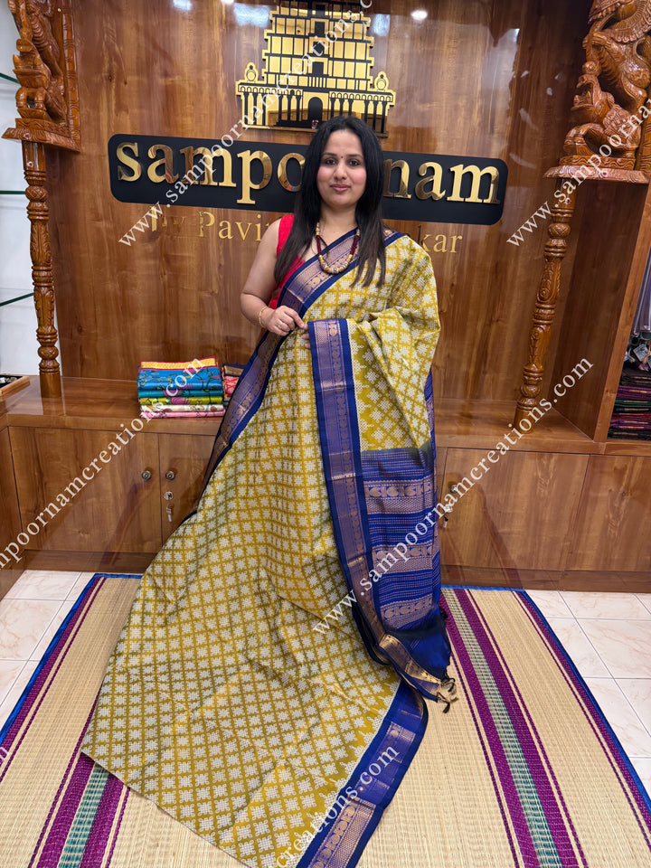 Dark Gold with Dark Blue Kolam Prints all over the body , traditional borders and rich Pallu Korvai Silk Cotton Saree