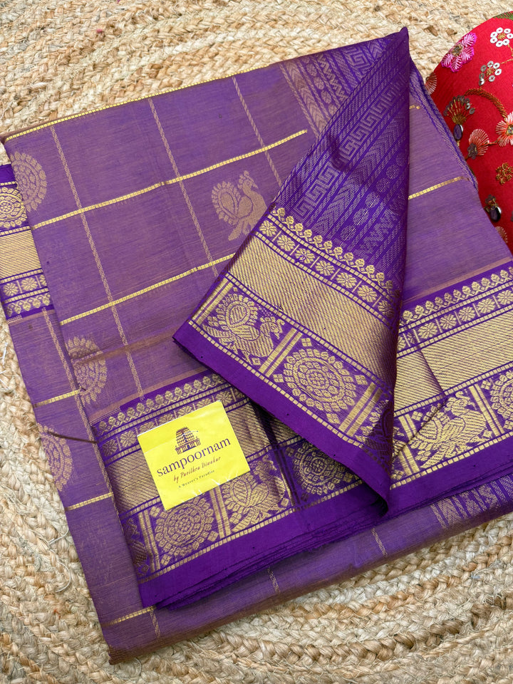Mauve with Purple  , rich Zari checks with Mayil Chakram butta in the body , traditional borders and  rich Pallu Korvai Silk Cotton Saree