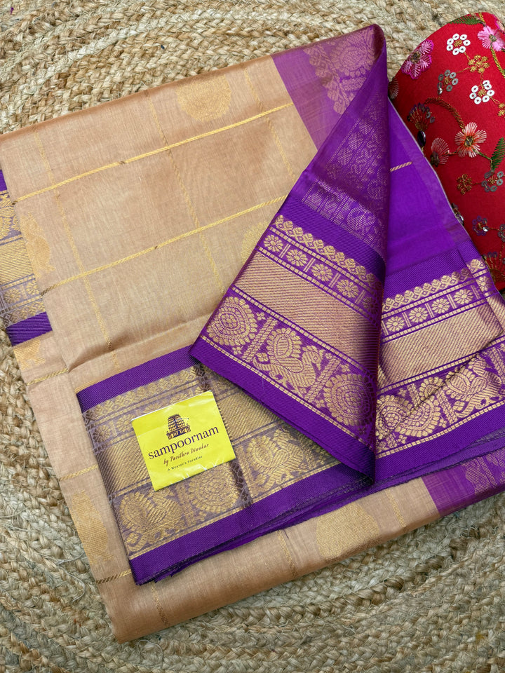 Biscuit with Purple  , rich Zari checks with Mayil Chakram butta in the body , traditional borders and rich Pallu Korvai Silk Cotton Saree