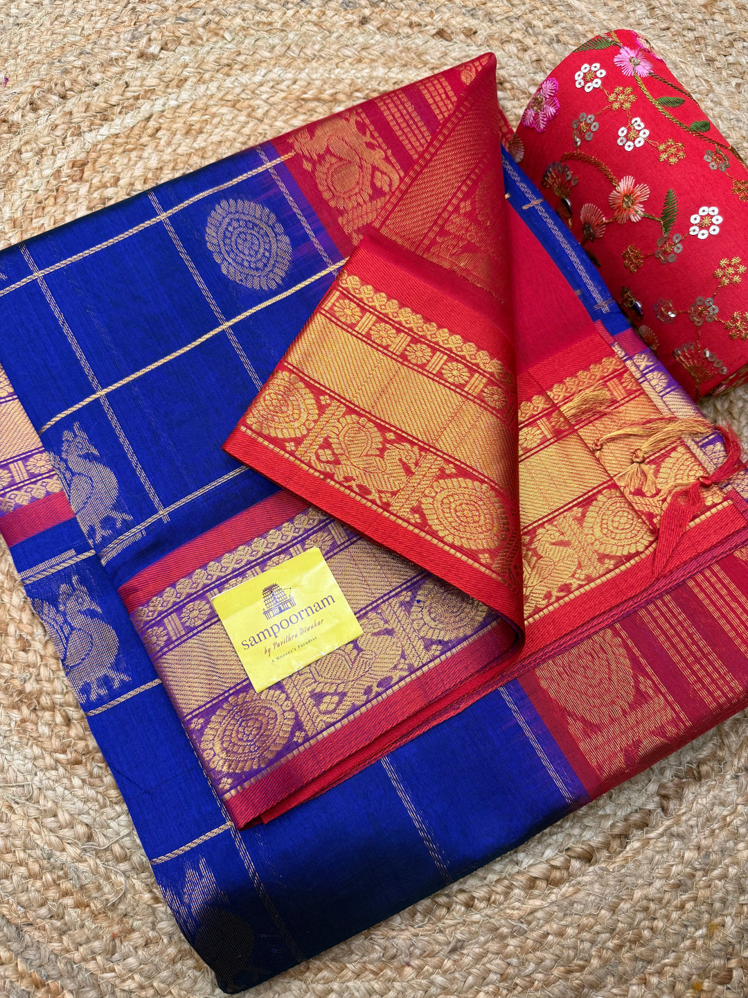Royal Blue with Red  , rich Zari checks with Mayil Chakram butta in the body , traditional borders and rich Pallu Korvai Silk Cotton Saree