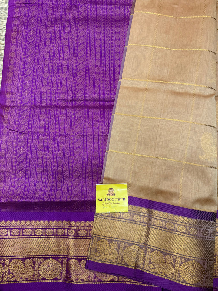 Biscuit with Purple  , rich Zari checks with Mayil Chakram butta in the body , traditional borders and rich Pallu Korvai Silk Cotton Saree