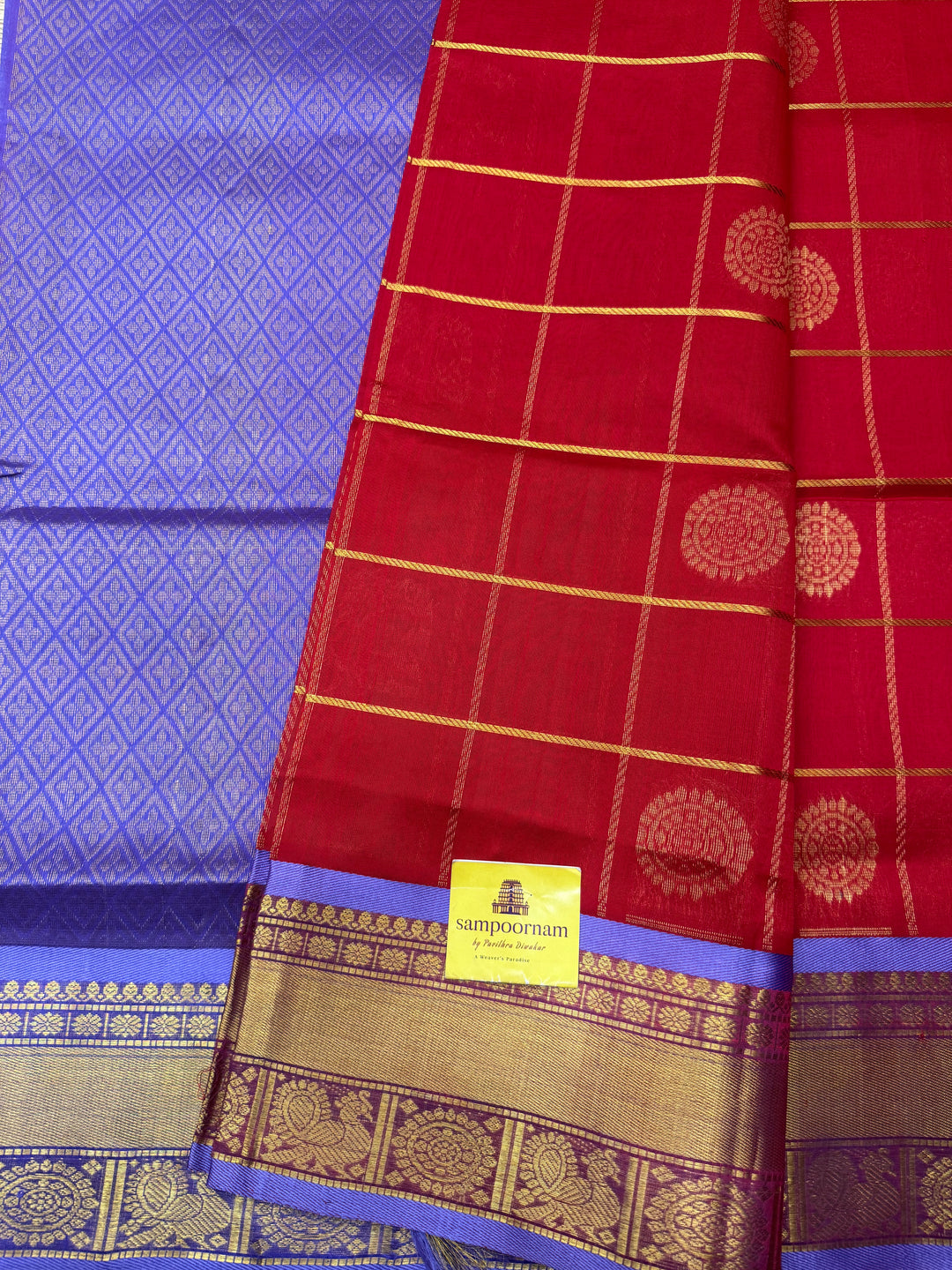 Red with Lilac  , rich Zari checks with Mayil Chakram butta in the body , traditional borders and  rich Pallu Korvai Silk Cotton Saree