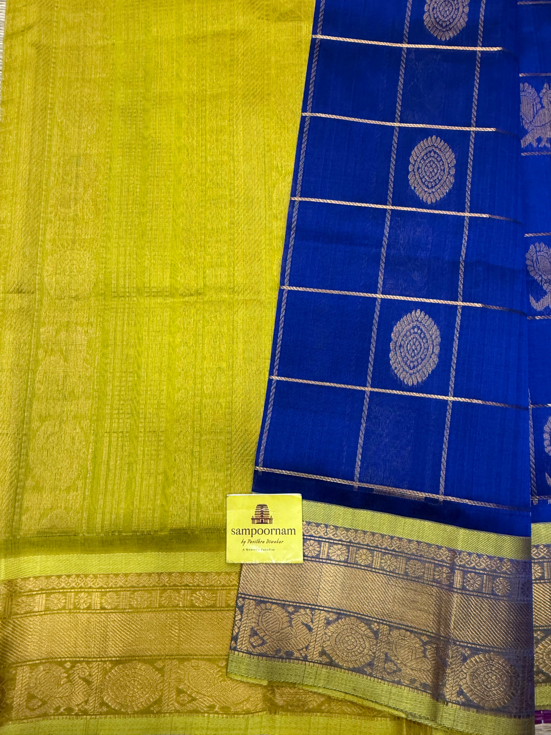 Indigo Blue with Lemon Green  , rich Zari checks with Mayil Chakram butta in the body , traditional borders and  rich Pallu Korvai Silk Cotton Saree
