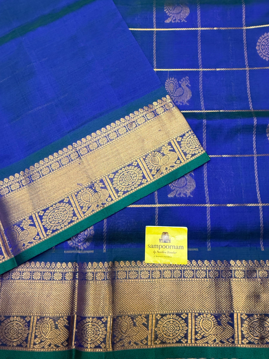 Mayilkazhuthu ,  rich Zari checks with Mayil Chakram butta in the body , traditional borders and  rich Pallu Korvai Silk Cotton Saree