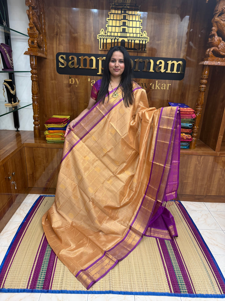 Biscuit with Purple  , rich Zari checks with Mayil Chakram butta in the body , traditional borders and rich Pallu Korvai Silk Cotton Saree