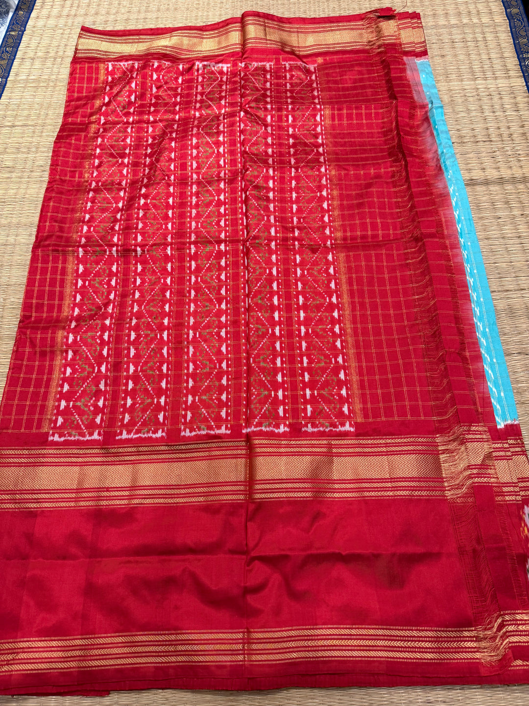 A Gorgeous Pastel Blue with Red saree , with rich Zari checks in the body and one side big Peacock design border and Grand Pallu Pure Pochampally Silk Saree