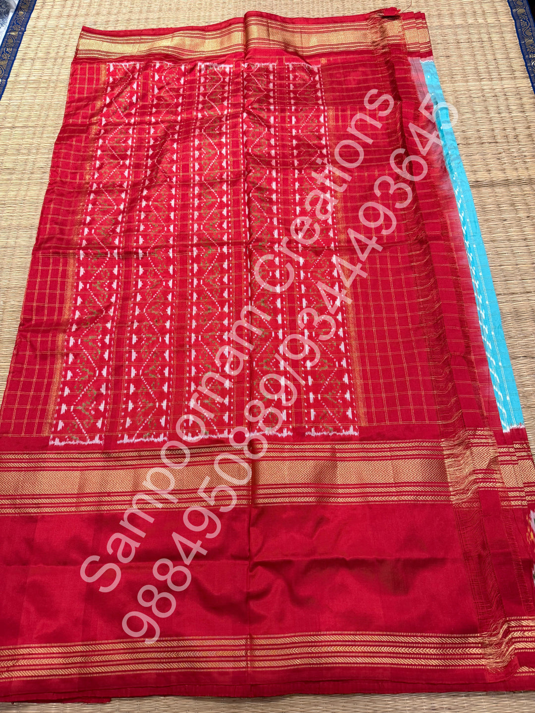 A Gorgeous Pastel Blue with Red saree , with rich Zari checks in the body and one side big Peacock design border and Grand Pallu Pure Pochampally Silk Saree