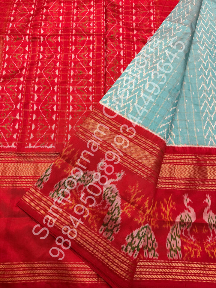 A Gorgeous Pastel Blue with Red saree , with rich Zari checks in the body and one side big Peacock design border and Grand Pallu Pure Pochampally Silk Saree