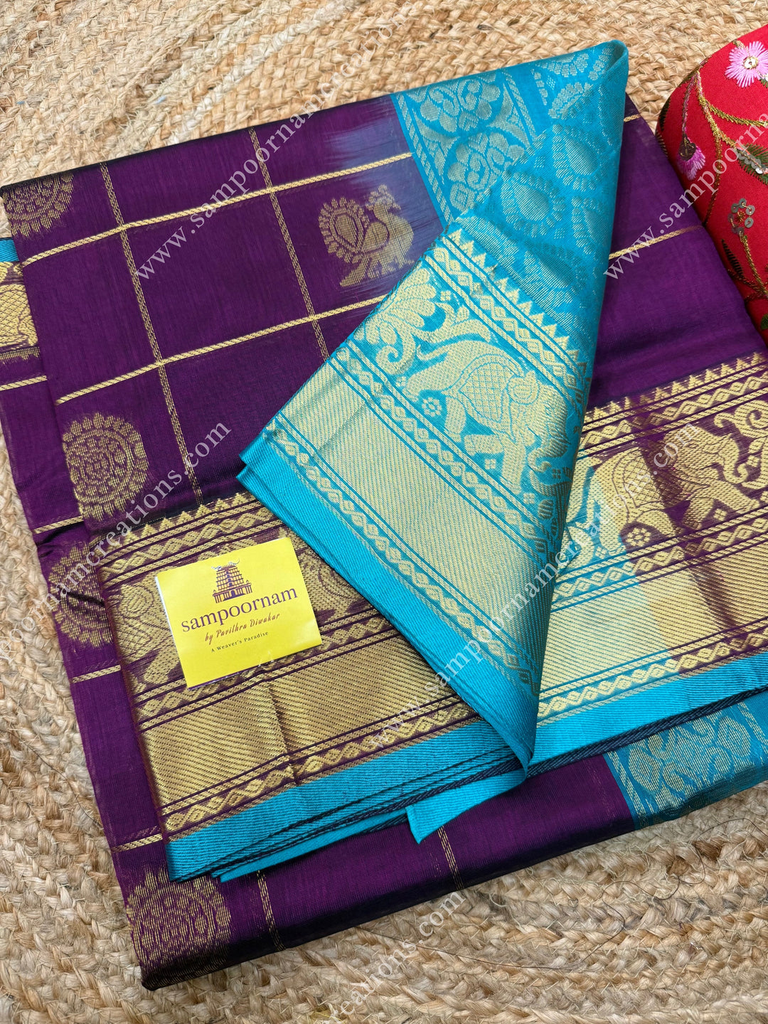Wine with Turquoise Blue  , rich Zari checks in the body , Mayil and Chakram rich butta in the body , one side Long traditional border rich Pallu Silk Cotton Saree
