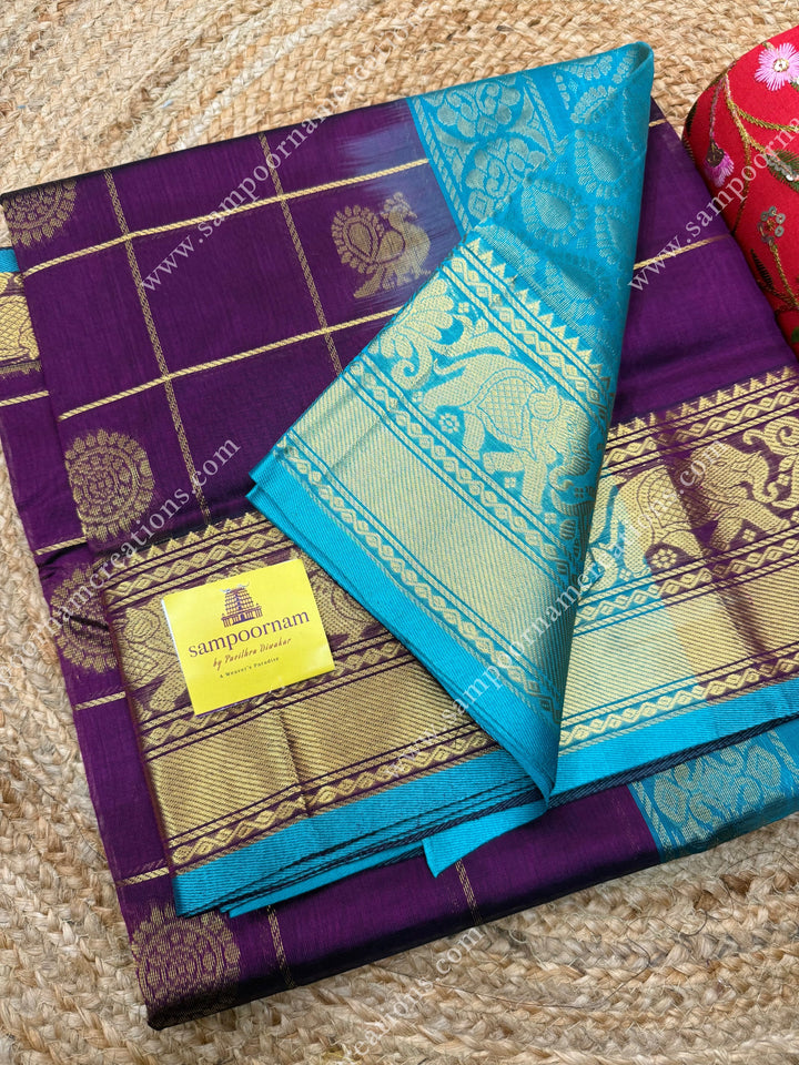 Wine with Turquoise Blue  , rich Zari checks in the body , Mayil and Chakram rich butta in the body , one side Long traditional border rich Pallu Silk Cotton Saree
